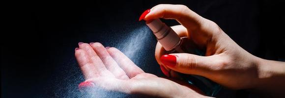 Young girl cleaning hands with alcohol sanitizer photo