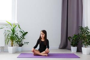 little girl do yoga at apartment photo