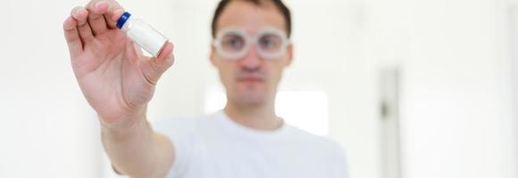 Taking decision. Focused photo on male hands that holding glass package with antivirus vaccine