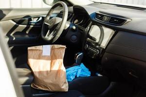 delivery man delivers orders by car. Delivery service under quarantine, disease outbreak, coronavirus covid-19 pandemic conditions. photo