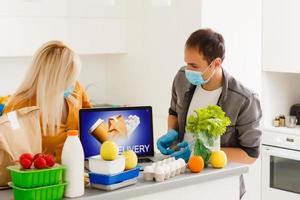 yo aislamiento concepto. Pareja desempacar papel bolso con comida en cocina, Listo para cuarentena durante epidemia brote foto