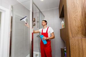 A man cleaning a shower glass photo