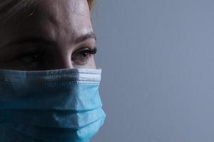 recortado imagen de hembra médico vistiendo médico máscara foto