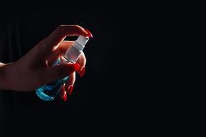 Young girl cleaning hands with alcohol sanitizer photo