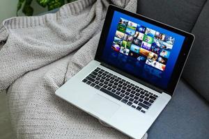 Panoramic shot of girl watching laptop while laying in bed with copy space photo