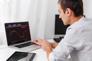 Close-up Of Businessman Analyzing Graph On Laptop At Workplace In The Office photo