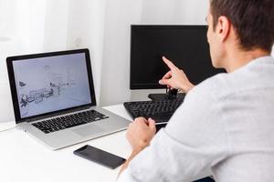 Happy designer working on his laptop in creative office photo