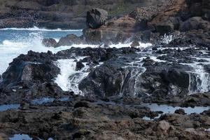 Large waves crashing against the rocks in the ocean photo