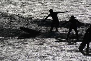 joven Atletas practicando el agua deporte de surf foto
