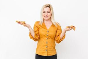 contento joven mujer comiendo rebanada de caliente pizza, aislado en blanco foto