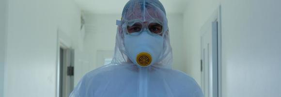 Scientist in protective wear, glasses and respirator photo