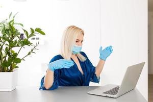 Woman in quarantine wearing protective mask and smart working photo