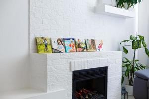 Frames collage with floral posters on bricks textured wall, over modern couch, interior decor mock up photo