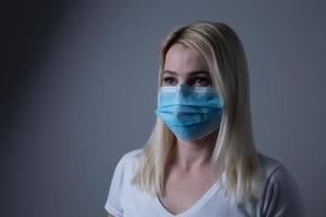 An unhappy woman wearing a face mask to deal with virus or pollution. photo