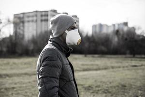 un hombre vistiendo un máscara en el calle. proteccion en contra virus y apretón foto