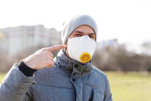 Young man wearing a face mask to protect against flu or infections photo