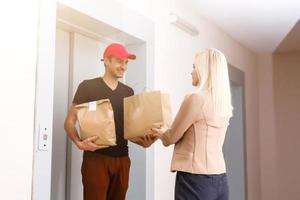 un hermoso joven entrega hombre entregando un paquete a Departamento foto