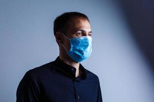 Strong man wearing mask to prevent flu virus and dust air pollution on white background photo