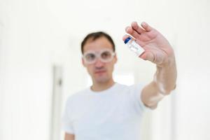 Taking decision. Focused photo on male hands that holding glass package with antivirus vaccine