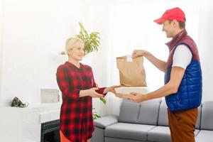 hombre comida entrega participación papel bolso en un Departamento foto