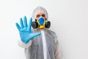 Man in protective clothing and a gasmask on a white background photo