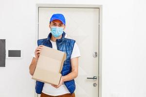 Delivery man holding paper bag with food on white background, food delivery man in protective mask photo