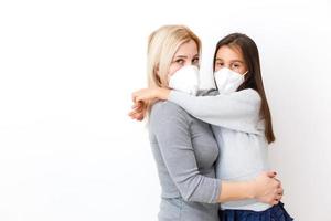 Daughter with mom in Surgical Masks. Family with kids in face mask ffp1. Virus and illness protection in public crowded place. Mother and daughter bed room wear protection mask, health care photo