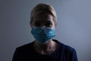 An unhappy woman wearing a face mask to deal with virus or pollution. photo