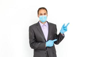 a man with a mask on his face for antivirus individual protection puts on medical sterile gloves - healthcare and medicine concept, prevention tips photo