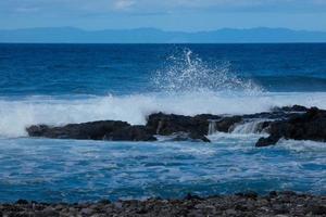 Large waves crashing against the rocks in the ocean photo