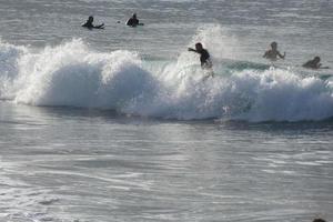 surfistas montando pequeño Oceano olas foto