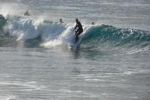 Surfers riding small ocean waves photo