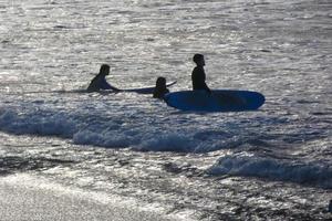 joven Atletas practicando el agua deporte de surf foto