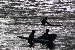 young athletes practising the water sport of surfing photo