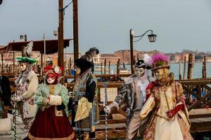 personas no identificadas con máscaras de carnaval en el carnaval de venecia en venecia, italia, alrededor de febrero de 2022 foto