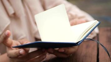 Close up of women hand turning a pager of a diary video