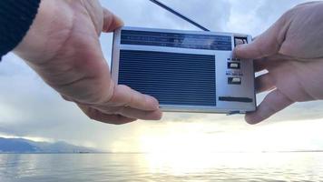 Searching for Radio Channels Tuning with Pocket Radio on a Cloudy Day at the Beach video