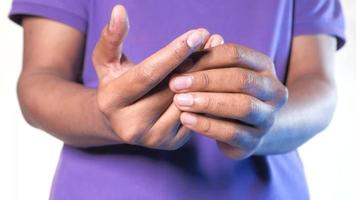 Man suffering pain in finger isolated on white, close up video