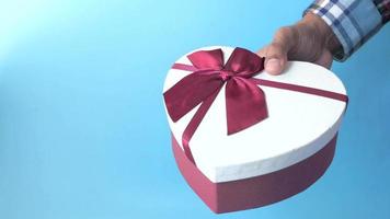 Man hand holding heart shape gift box video