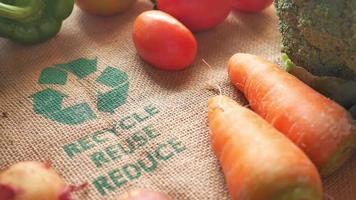 Bolsa de compras reutilizable con letrero de flechas recicladas y verduras en la mesa video