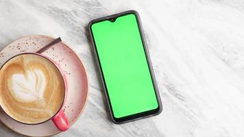 Clever Telefon mit Grün Bildschirm und Tasse von Kaffee auf Tabelle video