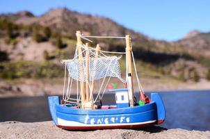 Toy ship on the rock photo