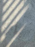 Leaves shadow background on concrete wall texture, leaves tree branches shade with sunlight photo