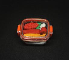 japonés comida Sushi pequeño borrador juguete miniatura estacionario con único linda forma. un manojo de linda Sushi conformado borrador dentro mini bento rojo el plastico almuerzo caja. foto