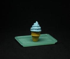 Ice cream shaped eraser. School or office stationary tool supplies with blue bubble gum ice cream cone shape . isolated photo on dark black background.