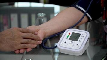 Doctor checking old female patient arterial blood pressure. Health care.Monitoring blood pressure of patients using upper arm blood pressure monitor in the video