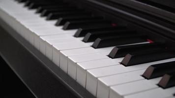 Close-up of piano keyboard with blurred background video