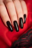 Hand of a young girl with black  manicure on nails photo