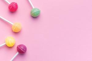 Sweet lollipops on pink background photo