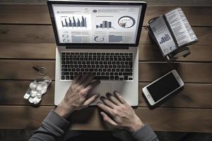 Web analytics and digital marketing. Top view of business man using laptop photo